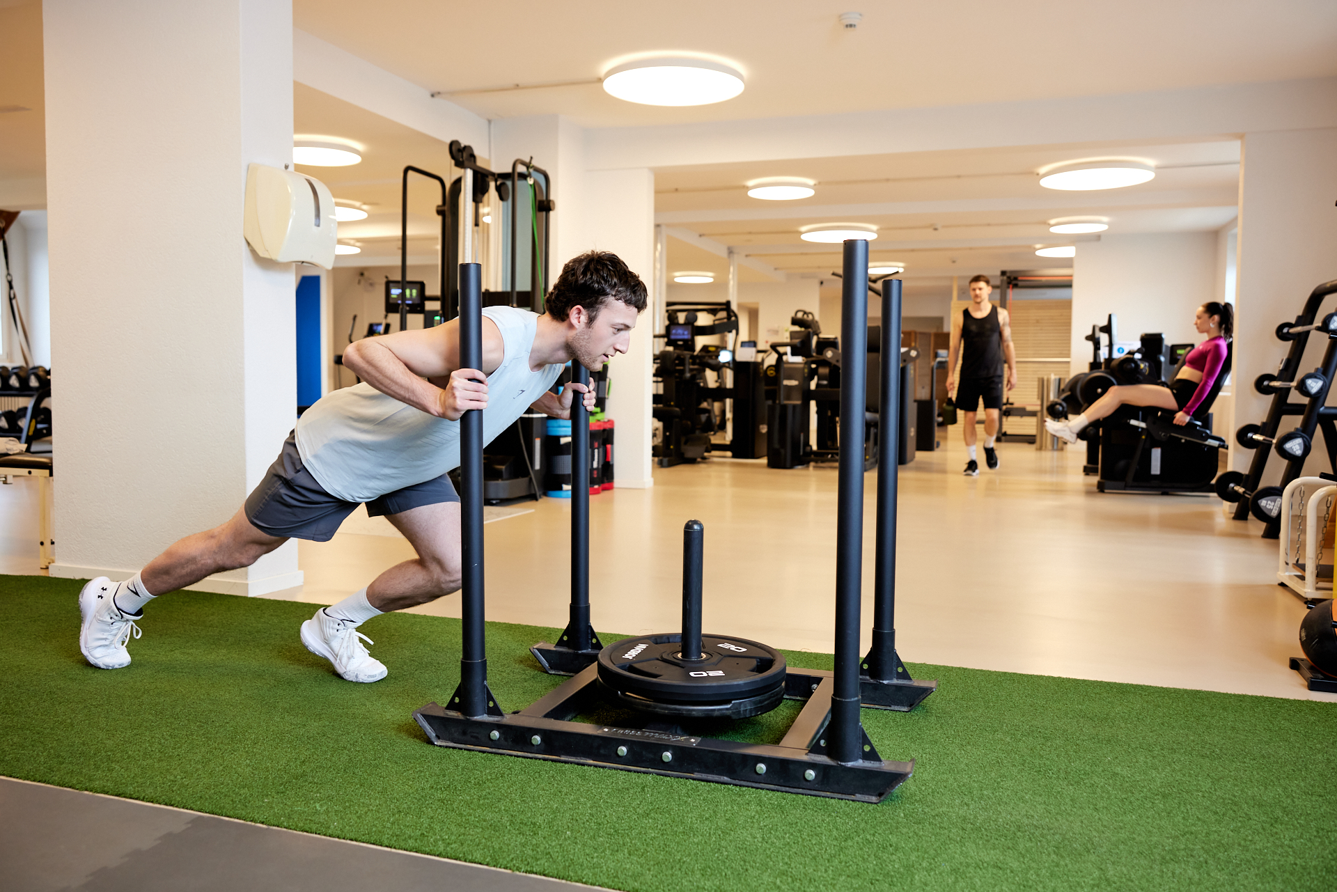 Trainer begleitet Athletin an funktionalem Gerät